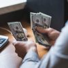 businessman-is-counting-dollars-banknotes-PCFS7CHJPG.jpg
